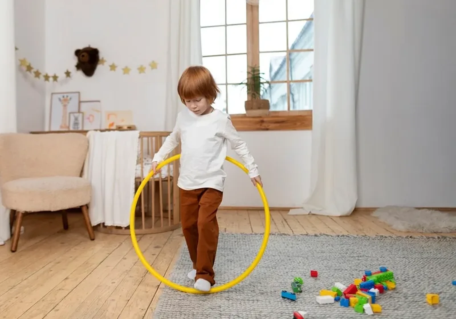 A child stepping through a large yellow hoop at home