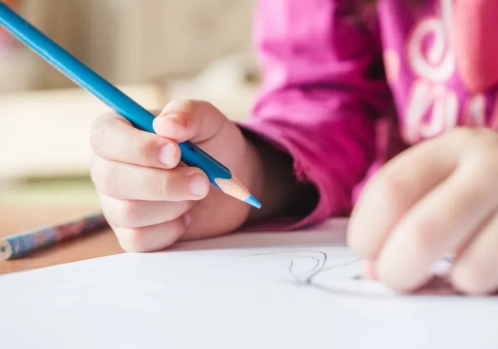 A child working on letter formation at a table
